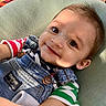 baby, child, smile, face, denim_overalls, striped_shirt, green, red, blue, cushion, closeup, portrait, cute, happy, infant, small, skin, eyes, hair, casual_clothing