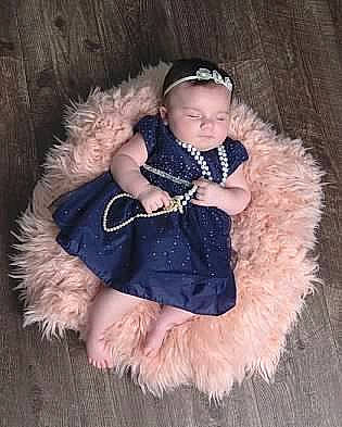 Adrianna joined the competition — help win amazing prizes! animal_product, baby, baby_toddler_clothing, carnivore, child, collar, companion_dog, dog_breed, embellishment, fashion_accessory, fawn, fur, fur_clothing, headgear, natural_material, person, pink, sitting, sleeve, textile