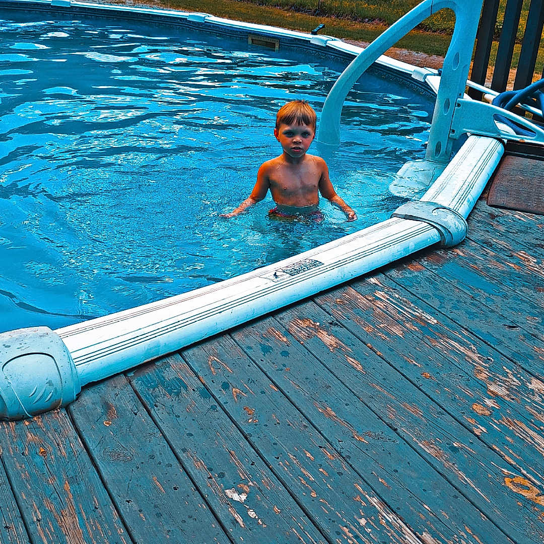 Daegin is registered to the contest to win money with this photo: backyard, blue, boy, child, daytime, deck, grass, leisure, nature, outdoor, person, playing, pool, recreation, summer, swimming, trees, water, wood, young