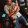Laeton is registered to the contest to win money with this photo: man, baby, tattoo, couch, leather, indoor, holding, sleeping, camouflage, clothing, jeans, ripped_jeans, smartphone, wood_floor, decor, home, relaxing, portrait, person, casual