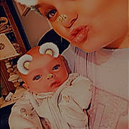 Laeton is registered to the contest to win money with this photo: baby, person, face, closeup, selfie, sparkle_filter, bear_ears, glitter_nose, cute, indoor, clothing, eyelashes, head, holding, infant, warm_lighting, soft_focus, expression, portrait, family