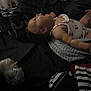 Londyn is registered to the contest to win money with this photo: baby, child, sleeping, blanket, bed, fabric, clothing, person, indoor, dark, cozy, resting, face, curly_hair, striped, pattern, soft, toddler, peaceful, portrait
