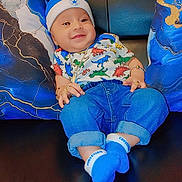 Yuvansh joined the competition — help win amazing prizes! baby, blue_hat, blue_socks, casual, child, couch, cute, denim_pants, dinosaur_shirt, fashion, hand, happy, indoor, jewelry, leather, person, pillow, portrait, relaxed, smiling