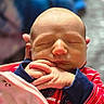 baby, newborn, sleeping, hands, face, clothing, striped, red, navy_blue, blanket, infant, peaceful, portrait, closeup, skin, person, cute, indoors, soft_light, young_child