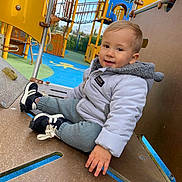 Ayden a rejoint le concours — aidez-le/la à gagner de superbes lots ! blue, casual_clothing, child, climbing_structure, daylight, fun, happy, jacket, kid, knit_pants, outdoor, park, person, play_equipment, playground, recreation, smile, sneakers, toddler, yellow