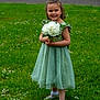 child, girl, flower_girl, bouquet, white_flowers, green_dress, smile, grass, outdoor, park, daisies, portrait, shoes, socks, happy, standing, hands, face, young_child, ceremony