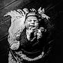 newborn, baby, black_and_white, portrait, teddy_bear, headband, blanket, cozy, sleeping, cute, infant, soft_lighting, wooden_floor, wrapped, peaceful, child, indoors, small, hands, face