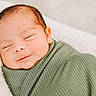 newborn, baby, infant, sleeping, smiling, wrapped, blanket, green_blanket, closeup, face, peaceful, soft_light, cozy, resting, portrait, cute, child, fresh, toddler, bed