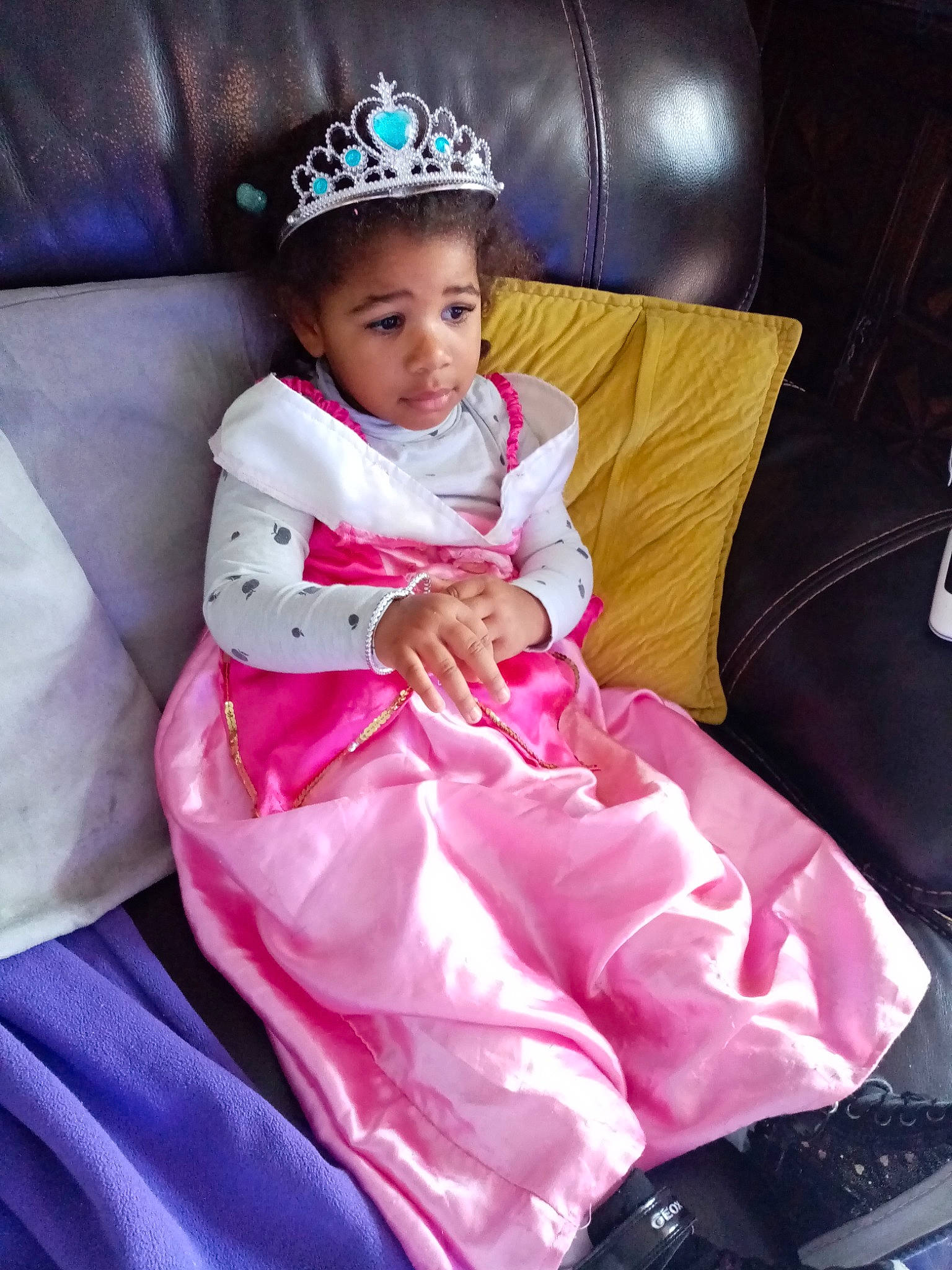 Johanie participe au concours pour gagner de l'argent avec cette photo : baby, baby_toddler_clothing, bonnet, child, comfort, costume, costume_accessory, couch, hair_accessory, headband, headgear, headpiece, human_body, lap, living_room, person, pink, purple, sitting, tiara