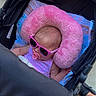 baby, stroller, pink_sunglasses, pacifier, neck_pillow, blanket, infant, child, outdoor, footwear, legs, person, clothing, shade, comfort, cute, relaxation, accessories, casual, summer