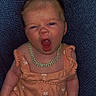 Dylan joined the competition — help win amazing prizes! baby, infant, romper, orange_clothing, necklace, gold_chain, yawning, sitting, cushion, fabric, texture, indoors, person, cute, small, child, skin, head, arm, legs
