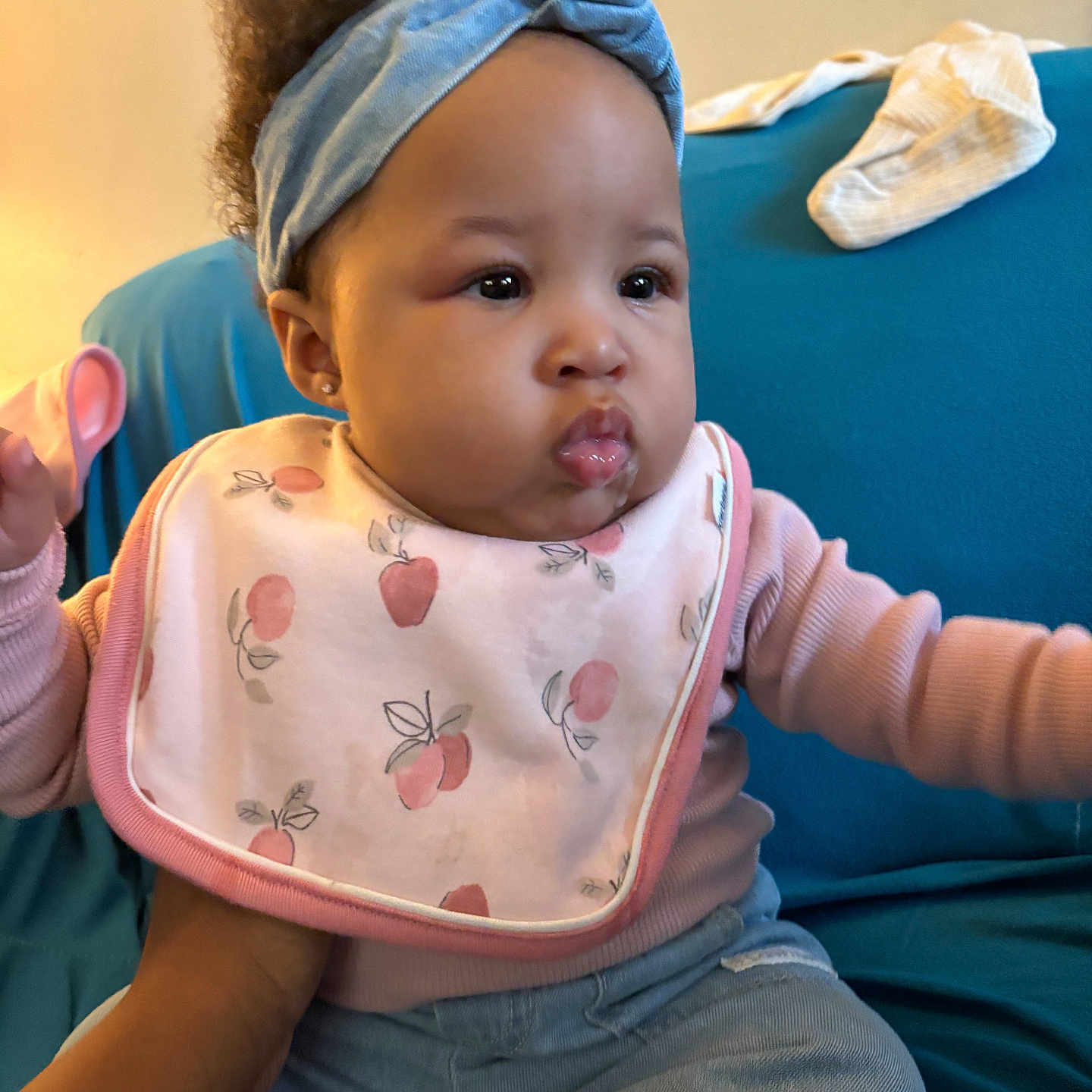 Rhyann is registered to the contest to win money with this photo: accessories, baby, babylaughing, bib, bodypart, couch, eating, face, finger, food, furniture, hand, happy, head, headband, person, photography, portrait, sitting, smile