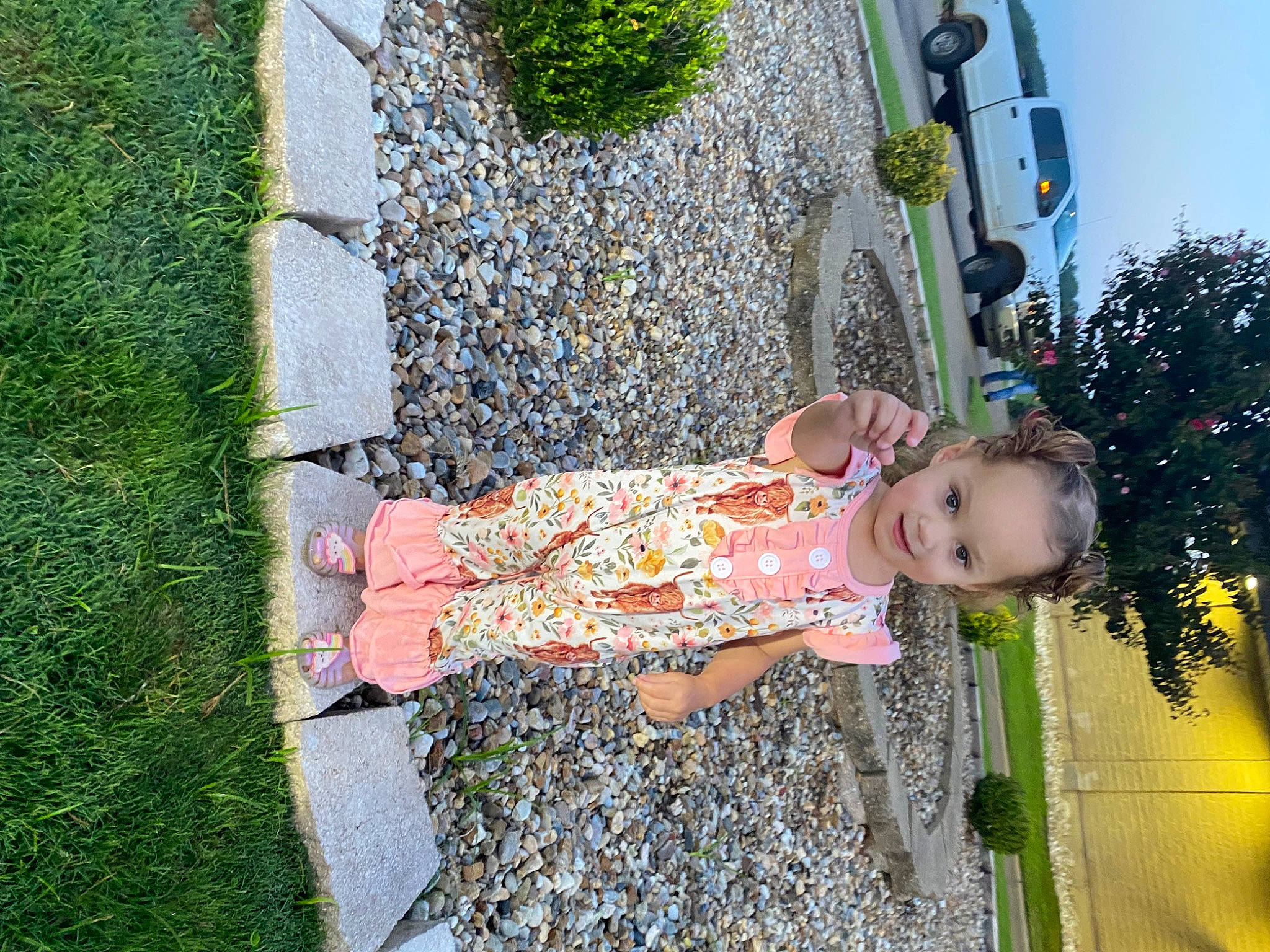 Millie is registered to the contest to win money with this photo: baby_toddler_clothing, car, child, dress, fun, grass, green, happy, human_leg, joy, leisure, pattern, people_in_nature, person, plant, recreation, sky, street_light, toddler, tree