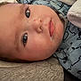 Preston is registered to the contest to win money with this photo: baby, face, close_up, drool, infant, blue_clothing, animal_print, lying_down, curious_look, skin, eyelashes, cheeks, head, portrait, child, cute, indoors, fabric, blanket, soft