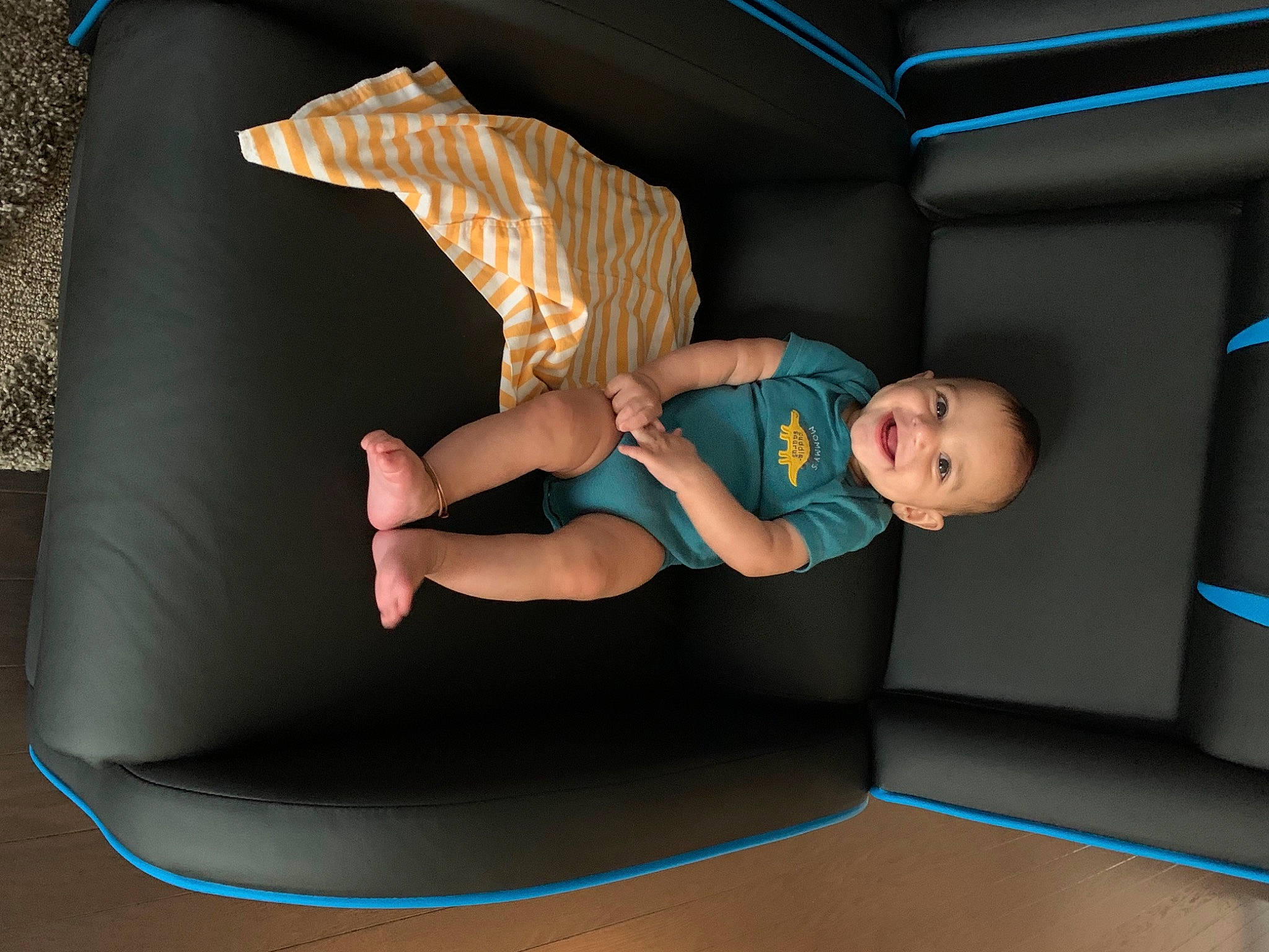 Avi is registered to the contest to win money with this photo: baby, baby_toddler_clothing, balance, barefoot, blue, child, comfort, electric_blue, floor, flooring, fun, human_leg, joy, knee, leg, leisure, person, sitting, sock, t_shirt