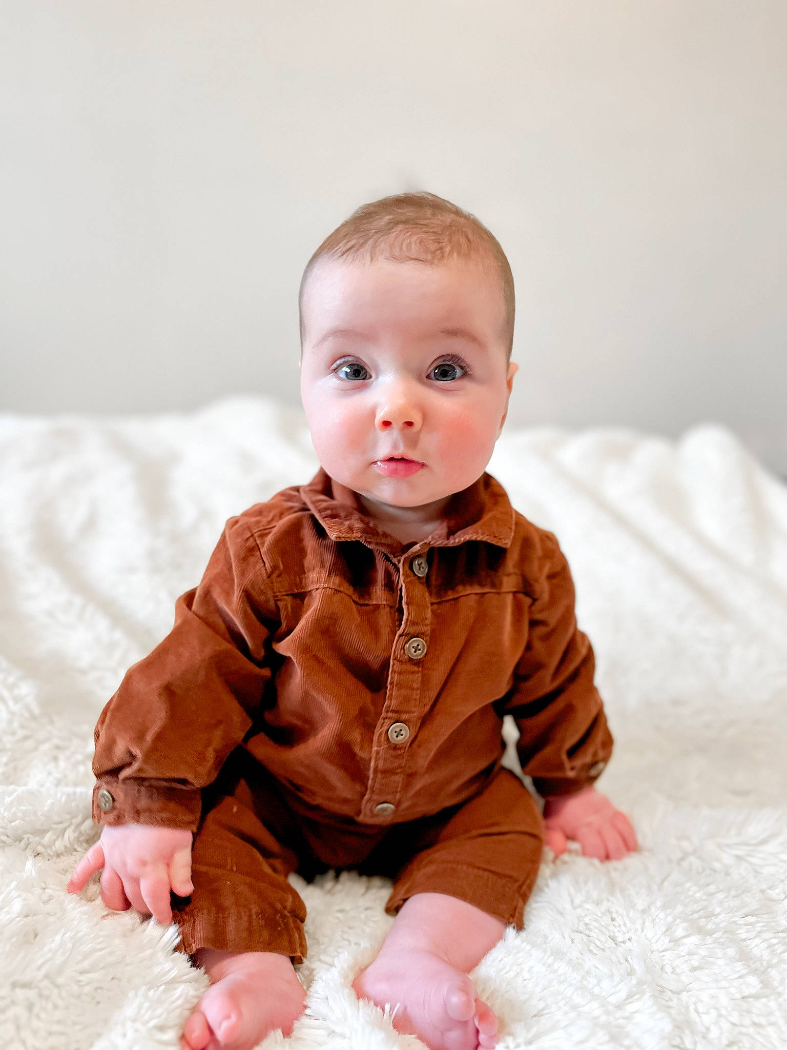 Harrison is registered to the contest to win money with this photo: baby, baby_toddler_clothing, cheek, child, collar, comfort, dress_shirt, eye, flooring, fur, happy, iris, linens, peach, person, portrait_photography, sitting, skin, sleeve, surprise