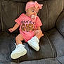 baby, infant, girl, pink_headband, bow, pacifier, pink_onesie, white_sneakers, couch, gray_couch, seated, child, clothing, footwear, indoor, cute, young_child, portrait, baby_fashion, headwear