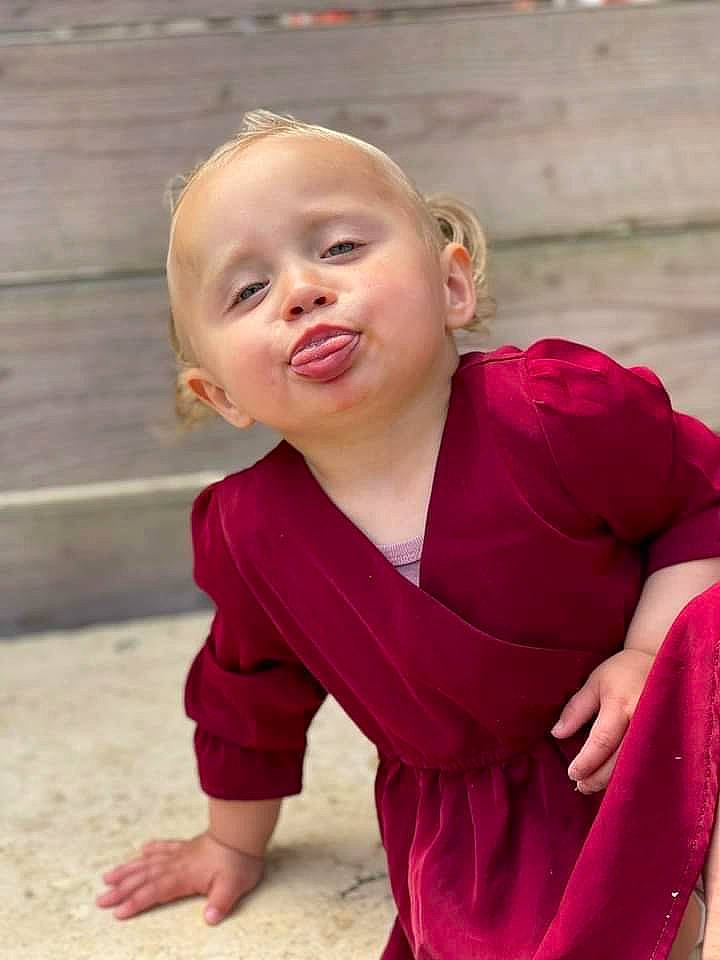 Thyphaine participe au concours pour gagner de l'argent avec cette photo : baby, baby_toddler_clothing, dress, gesture, grass, happy, human_body, lip, magenta, neck, person, pink, shoulder, skin, sleeve, smile, standing, t_shirt, toddler, window