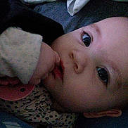 Neveah is registered to the contest to win money with this photo: baby, infant, face, eyes, hand, thumb, pacifier, pajamas, sleeve, polka_dot, closeup, portrait, indoor, bed, blanket, cheek, skin, laying_down, curious, low_light