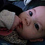 baby, infant, face, eyes, hand, thumb, pacifier, pajamas, sleeve, polka_dot, closeup, portrait, indoor, bed, blanket, cheek, skin, laying_down, curious, low_light
