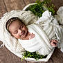 Sarina is registered to the contest to win money with this photo: baby, blanket, cozy, cute, greenery, headband, heart_shaped_basket, indoors, infant, knitted_fabric, newborn, peaceful, plant, portrait, sleeping, smiling, soft_texture, white, wooden_floor, wrapped