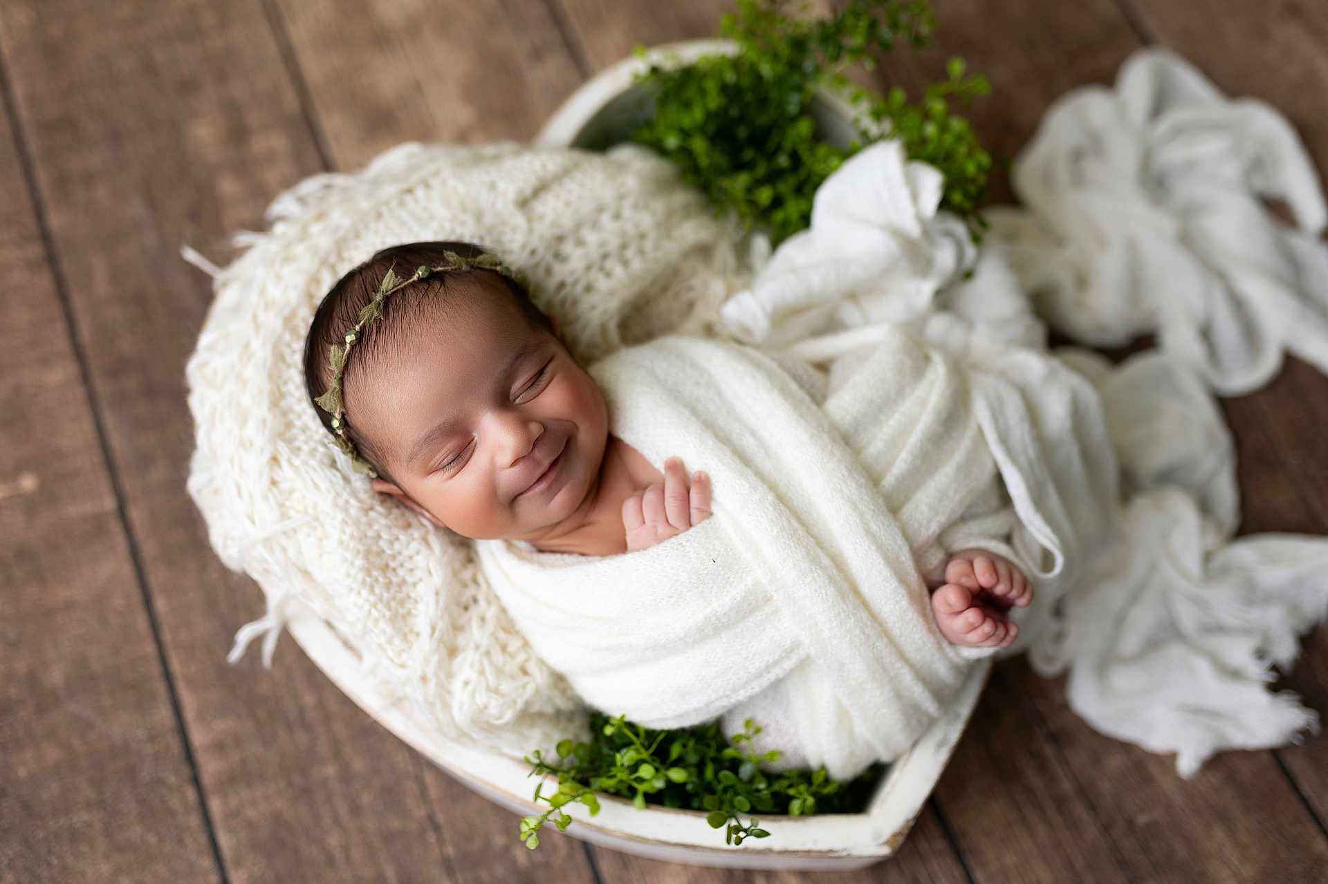 Sarina is registered to the contest to win money with this photo: baby, blanket, cozy, cute, greenery, headband, heart_shaped_basket, indoors, infant, knitted_fabric, newborn, peaceful, plant, portrait, sleeping, smiling, soft_texture, white, wooden_floor, wrapped