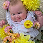 Skyé is registered to the contest to win money with this photo: baby, infant, flower, yellow_flower, pink_flower, smile, face, blanket, bib, cute, child, nature, petal, soft, closeup, skin, hand, lying_down, peaceful, adorable