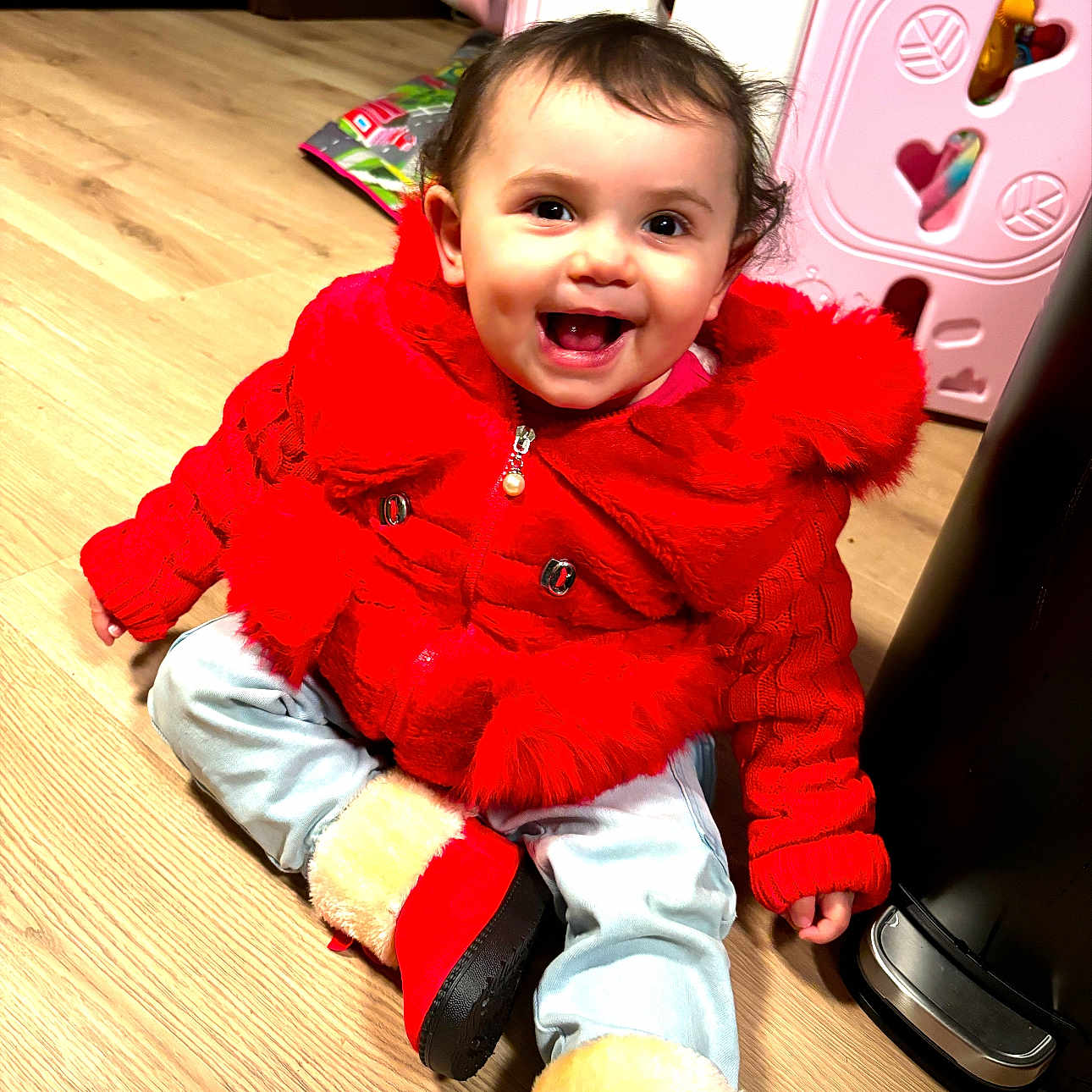 Zaniyah is registered to the contest to win money with this photo: baby, bodypart, clothing, coat, face, finger, hand, happy, hardwood, head, hood, jacket, knitwear, pants, person, photography, portrait, sitting, sweater, wood