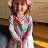 blue_eyes, child, couch, cute, dresser, floral_dress, girl, indoor, living_room, pink_hat, portrait, shadow, smile, socks, sunhat, sunlight, toddler, tongue_out, wardrobe, wooden_floor
