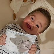 Liam a rejoint le concours — aidez-le/la à gagner de superbes lots ! baby, smiling, infant, plush_toy, card, striped_clothing, happy, lying_down, soft_surface, cute, child, indoors, face, holding, portrait, young_child, toy, baby_clothes, cheerful, childhood