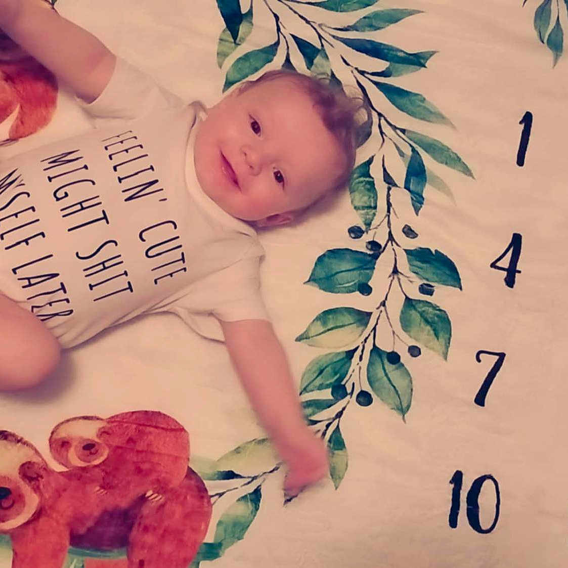 Elijah joined the competition — help win amazing prizes! age_marker, baby, blanket, child, cute, humorous_text, indoors, infant, leaf_pattern, lying_down, numbers, onesie, playful, portrait, skin, sloth, smiling, soft_toys, wreath, young_child