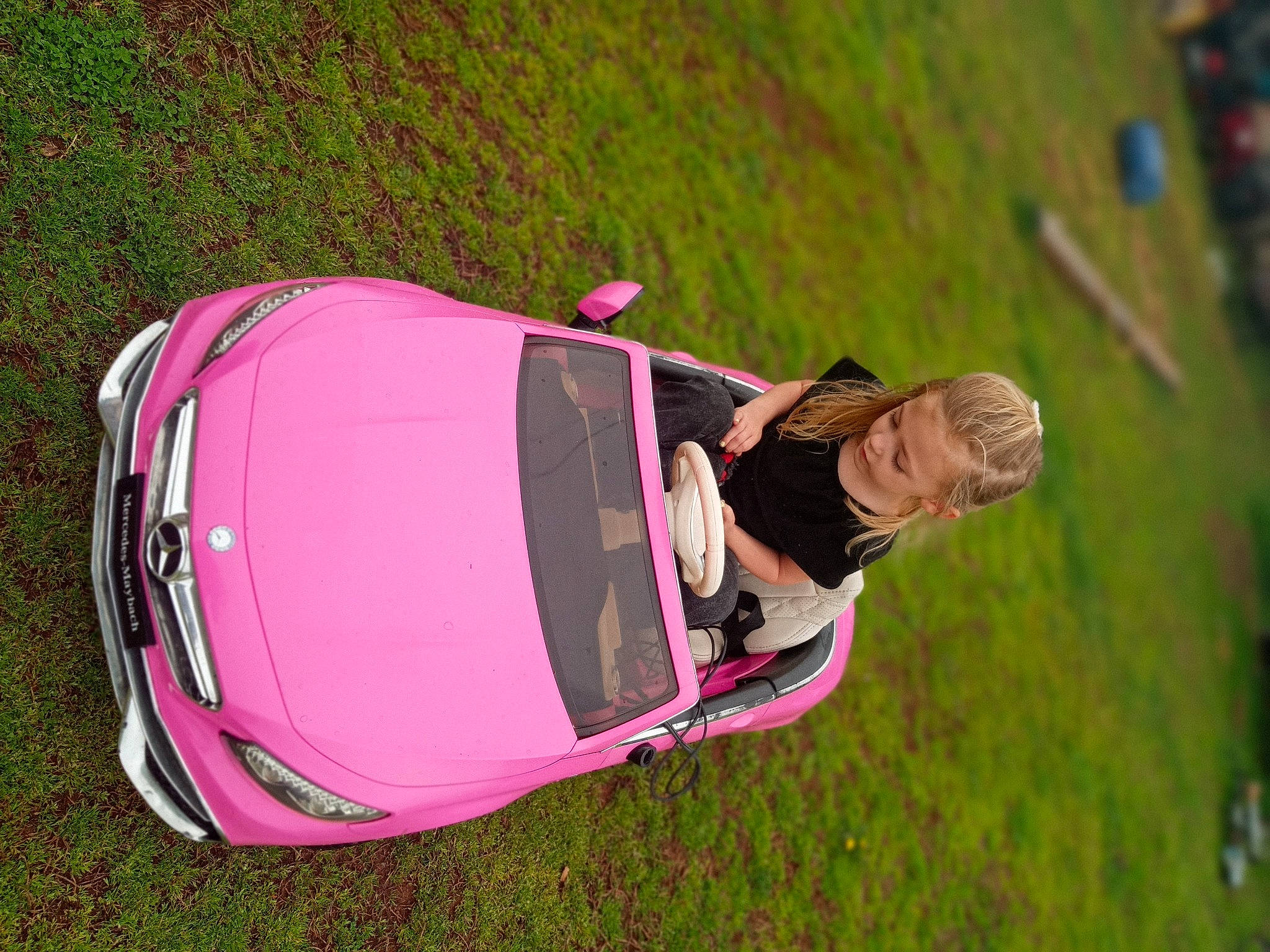 Ansley is registered to the contest to win money with this photo: automotive_design, automotive_exterior, automotive_lighting, bumper, car, family_car, grass, grassland, hood, landscape, magenta, motor_vehicle, person, personal_luxury_car, plant, tints_and_shades, tire, tree, trunk, vehicle