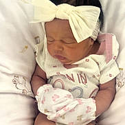 Sienna is registered to the contest to win money with this photo: baby, blanket, bow_headband, close_up, clothing, cozy, crib, cute, dark_hair, face, headband, indoors, infant, newborn, nursery, onesie, peaceful, portrait, sleeping, swaddle