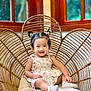 Sophia Hope Louise joined the competition — help win amazing prizes! toddler, child, smiling, sitting, wicker_chair, heart_shaped_chair, pigtails, indoors, window, wooden_frame, cushion, white_socks, dress, happy, cute, furniture, portrait, person, baby, home