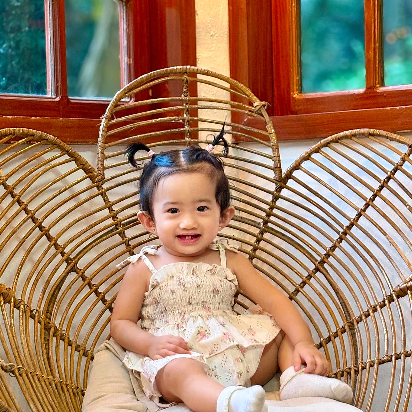 Sophia Hope Louise joined the competition — help win amazing prizes! baby, child, cushion, cute, dress, furniture, happy, heart_shaped_chair, home, indoors, person, pigtails, portrait, sitting, smiling, toddler, white_socks, wicker_chair, window, wooden_frame