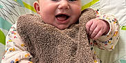 Eya a rejoint le concours — aidez-le/la à gagner de superbes lots ! baby, smiling, infant, bib, baby_seat, toy, colorful, clothing, happy, face, hand, cute, indoor, child, playful, floral_pattern, soft_texture, person, young_child, expression