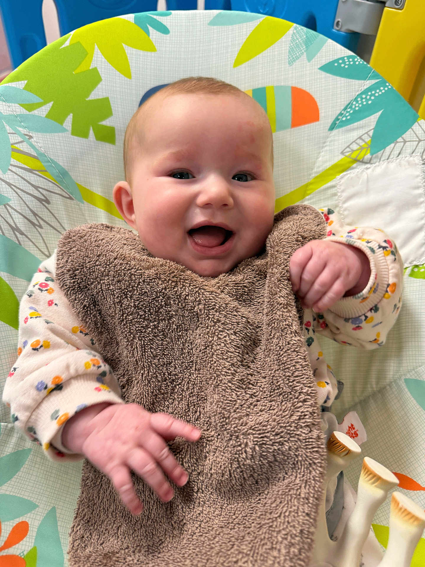 Eya a rejoint le concours — aidez-le/la à gagner de superbes lots ! baby, smiling, infant, bib, baby_seat, toy, colorful, clothing, happy, face, hand, cute, indoor, child, playful, floral_pattern, soft_texture, person, young_child, expression