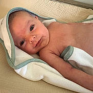 Mason joined the competition — help win amazing prizes! baby, infant, towel, smile, skin, lying_down, blanket, bed, comfort, cute, face, young_child, child, newborn, soft_texture, indoors, cozy, relaxed, portrait, resting