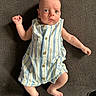 Mason is registered to the contest to win money with this photo: baby, infant, child, romper, striped_clothing, lying_down, barefoot, curious_expression, blue_eyes, small_fingers, small_toes, indoor, textured_surface, casual_clothing, cute, portrait, human, one_person, skin, head