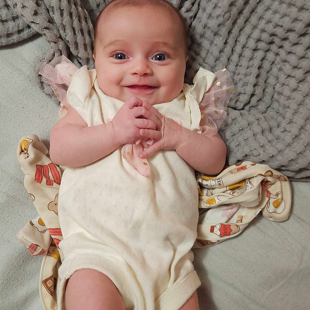 Ensley is registered to the contest to win money with this photo: baby, bed, bedroom, blanket, bodypart, couch, face, finger, furniture, hand, happy, head, indoors, newborn, person, photography, portrait, quilt, room, smile