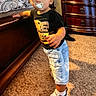 Elias is registered to the contest to win money with this photo: child, toddler, baby, boy, pacifier, cap, hat, black_shirt, denim_shorts, sneakers, standing, indoors, bedroom, dresser, furniture, carpet, bedding, portrait, fashion, smiling