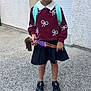 Mya a rejoint le concours — aidez-le/la à gagner de superbes lots ! child, girl, doll, backpack, sweater, skirt, shoes, bows, earrings, sidewalk, wall, outdoor, smiling, standing, play, toy, fashion, portrait, hair, accessories