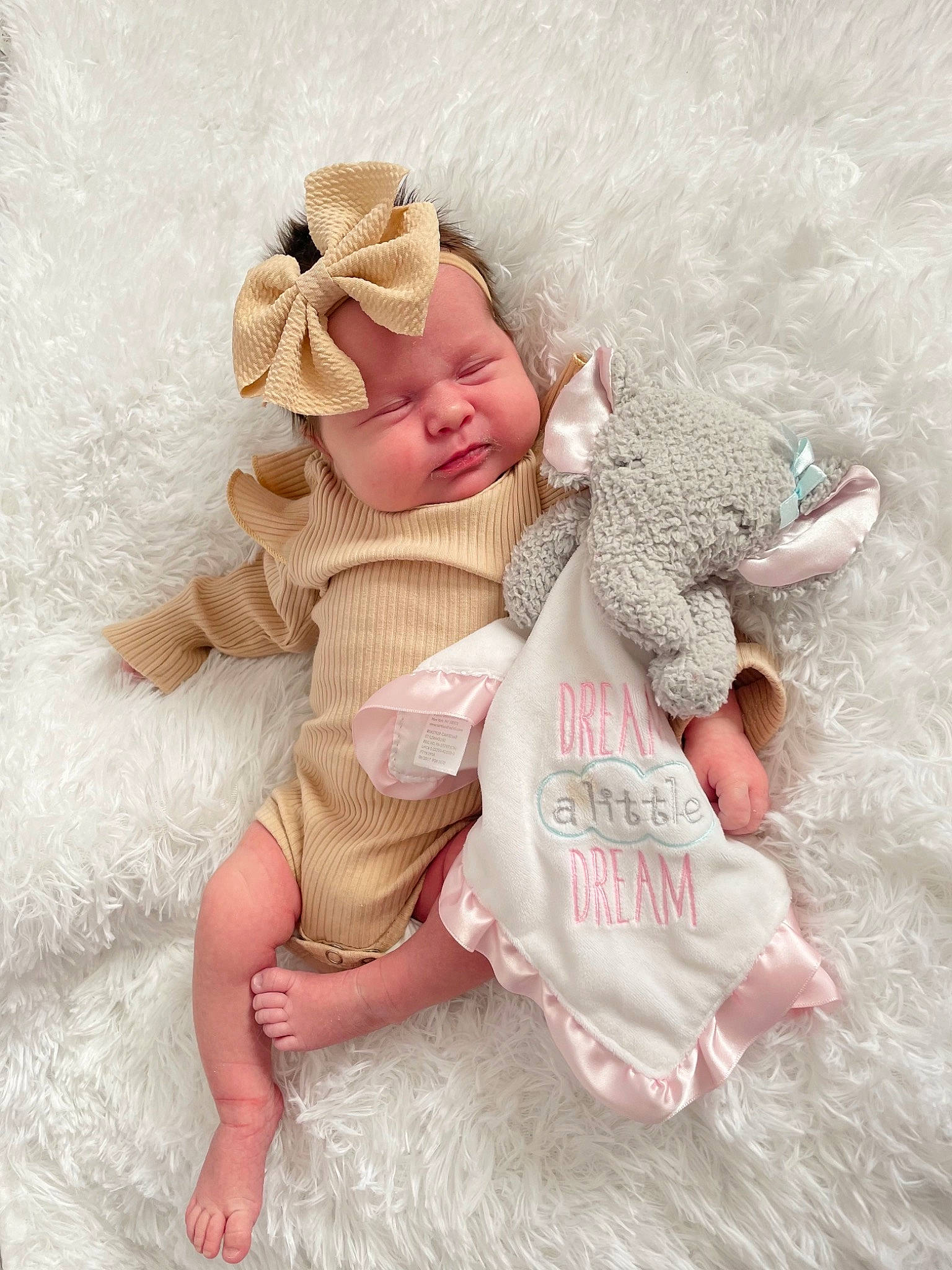 Harper is registered to the contest to win money with this photo: baby, baby_sleeping, baby_toddler_clothing, barefoot, child, comfort, fashion_accessory, fawn, flooring, foot, fur, gesture, hair_accessory, happy, head, linens, person, pink, sitting, sleeve