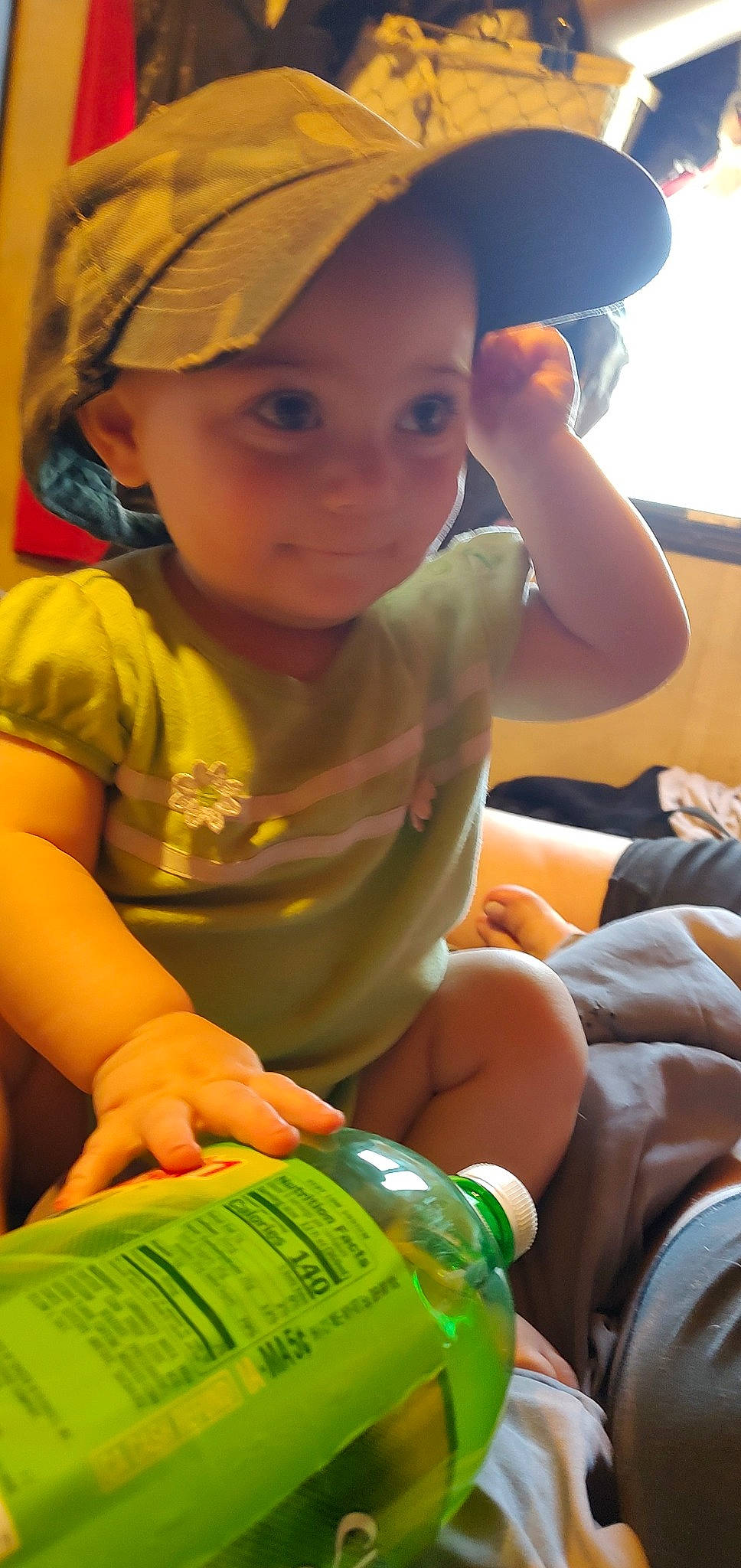 Mira is registered to the contest to win money with this photo: cap, child, elbow, facial_expression, finger, fun, green, happy, headwear, human, leisure, light, organ, person, photograph, skin, snapshot, summer, t_shirt, thigh