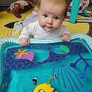 Lidia joined the competition — help win amazing prizes! baby, blue_eyes, water_mat, toy, indoor, play_area, colorful, infant, curious, soft_lighting, carpet, plush_toy, hand, face, clothing, floor, child, early_childhood, playtime, crawling