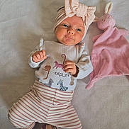 Noa joined the competition — help win amazing prizes! baby, headband, bow, pink, striped_pants, socks, plush_toy, bunny, soft_surface, cute, infant, child, lying_down, clothing, toy, indoors, portrait, expression, baby_girl, sleeping_area