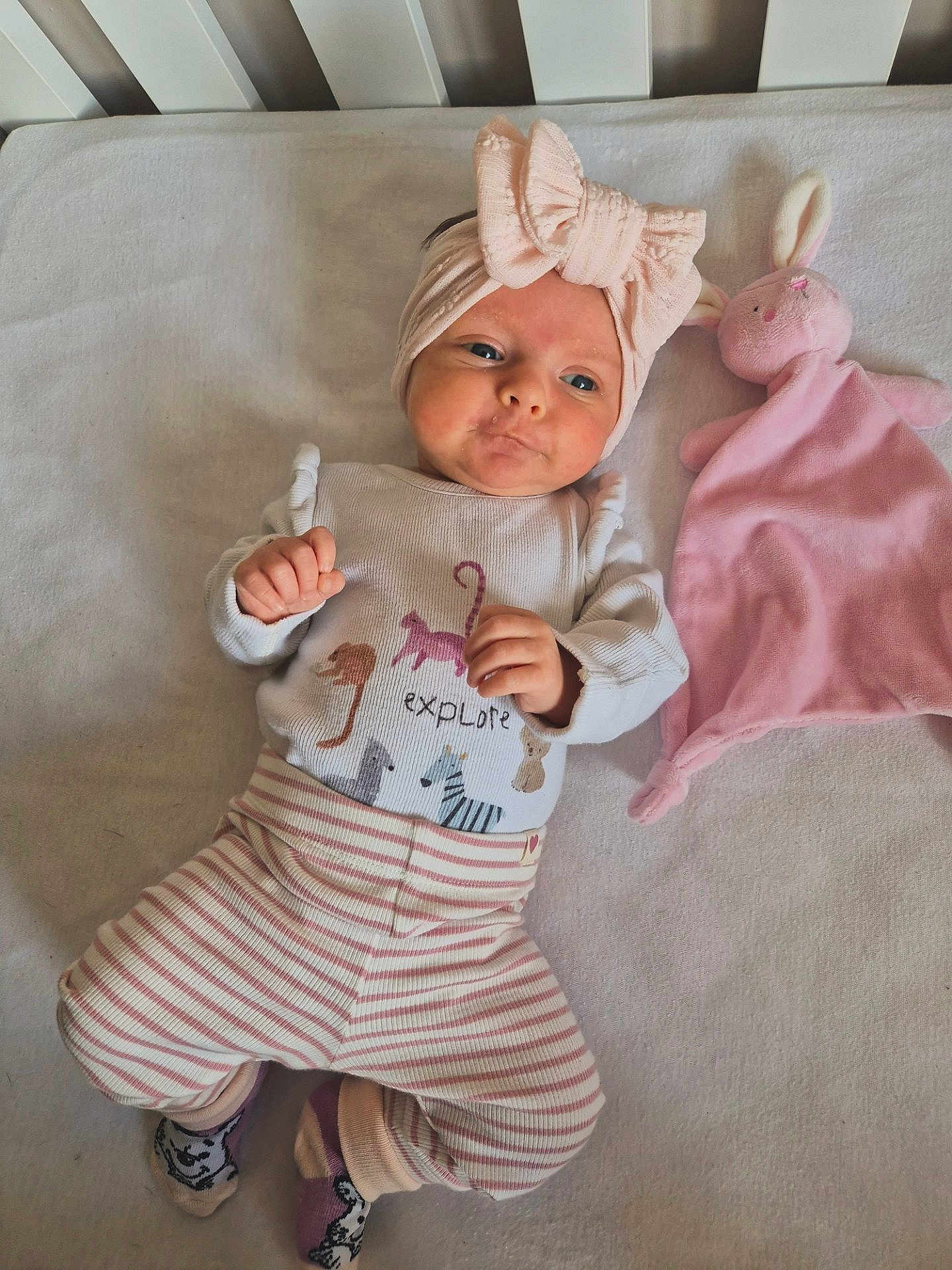 Noa joined the competition — help win amazing prizes! baby, headband, bow, pink, striped_pants, socks, plush_toy, bunny, soft_surface, cute, infant, child, lying_down, clothing, toy, indoors, portrait, expression, baby_girl, sleeping_area