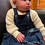baby, child, barefoot, denim, overalls, sweater, knitwear, indoor, furniture, chair, wood_paneling, cute, portrait, face, hands, feet, earrings, expression, seated, cozy