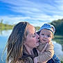 Charly a rejoint le concours — aidez-le/la à gagner de superbes lots ! affection, baby, blue_sky, casual_clothing, close_up, daylight, family, greenery, hat, holding, lake, long_hair, love, nature, outdoor, portrait, sky, smiling_baby, water, woman