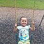 casual_clothing, child, daytime, fun, grass, happy, nature, outdoor, park, person, playground, recreation, shirt, shorts, smiling, summer, swing, tree, wood_chips, yellow_chains